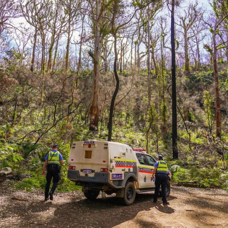Two Police Officers either side of a squad car in a Mount Barker forest.